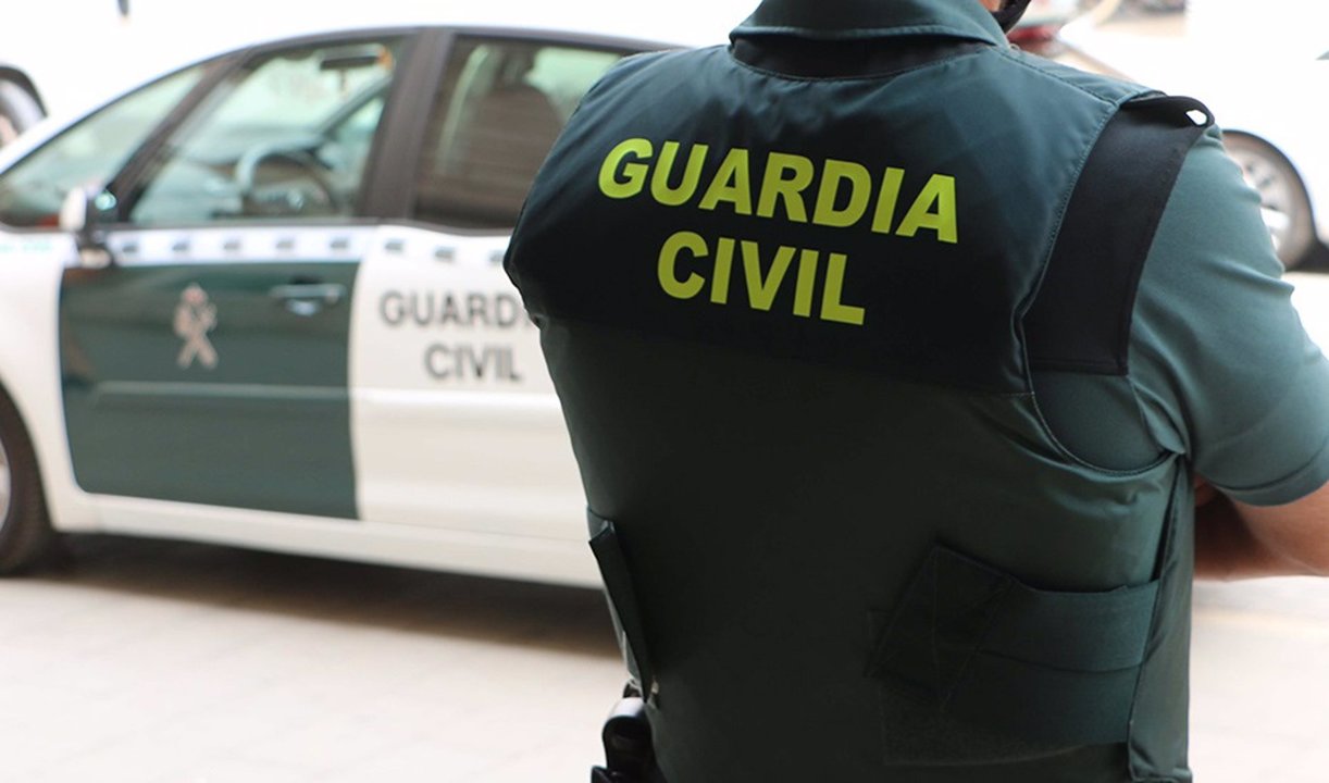 Un agente de la Guardia Civil, de espaldas, junto a un vehículo oficial. (foto: Guardia Civil)