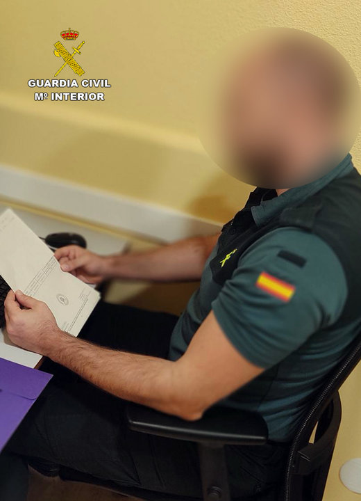 Un agente de la Guardia Civil con un documento vinculante en la operación "Romance Scam" | FOTO: GUARDIA CIVIL