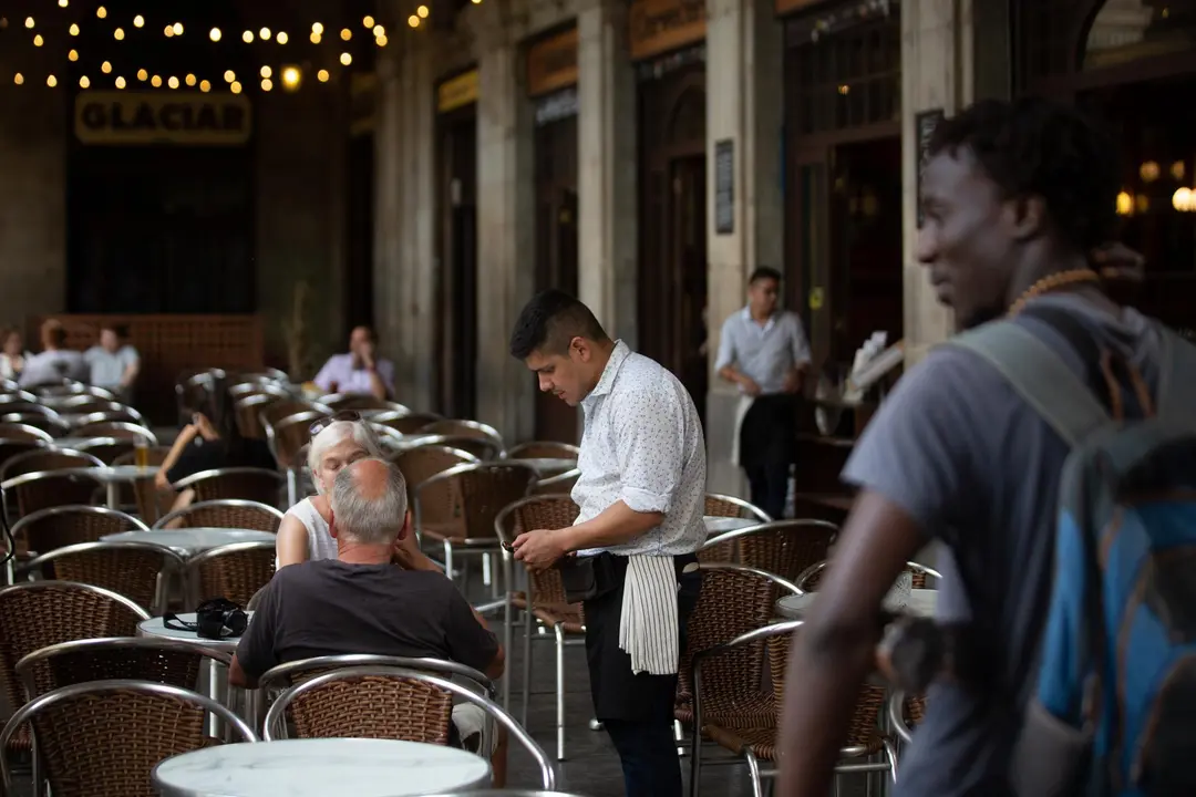 Un camarero atiende a una mesa