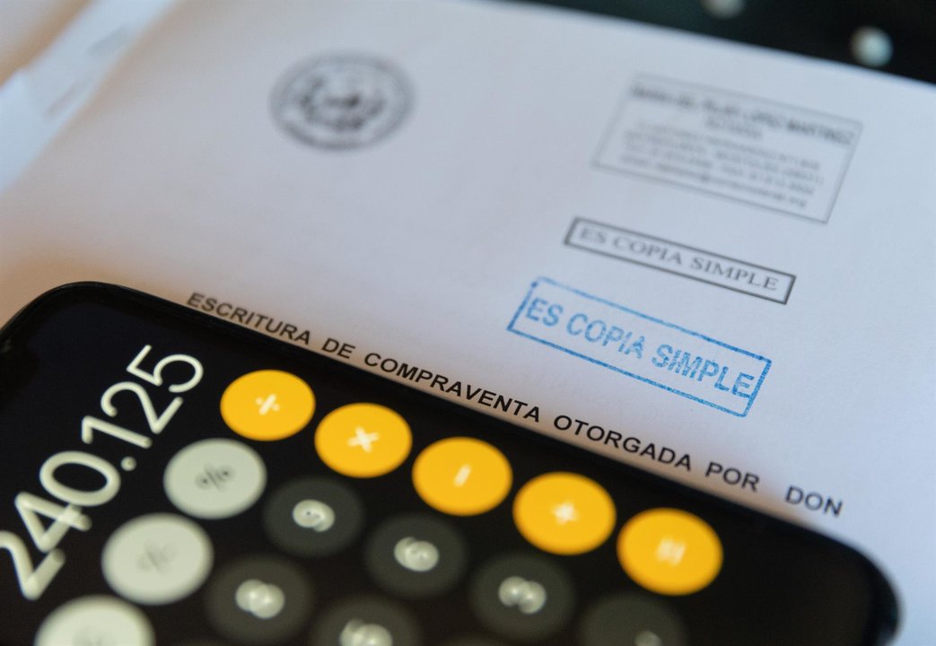 Una calculadora y una escritura de compraventa de una hipoteca (foto: Europa Press)