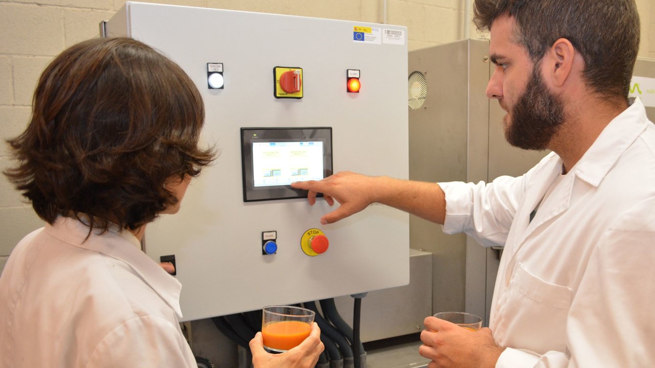 Investigadores de la Escuela de Agrónomos de la UPCT utilizando un equipo tecnológico para la pasteurización de un batido de tomate (foto: UPCT)