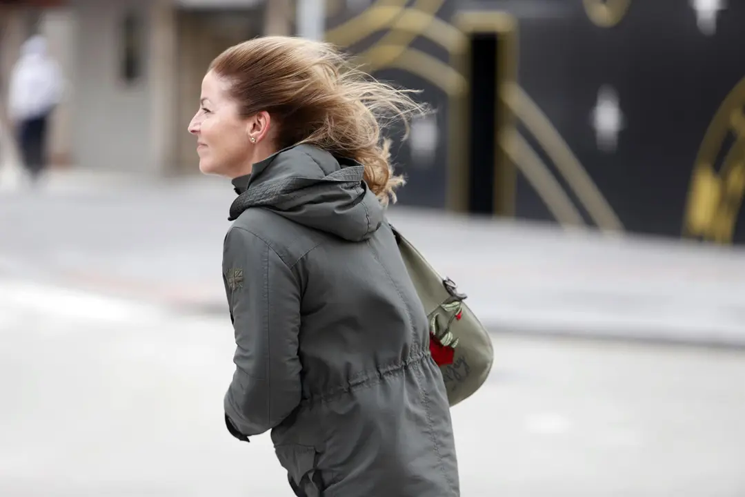 Varias personas intentan andar por la calle con temporal con vientos de 70 km/h (foto: Europa Press)