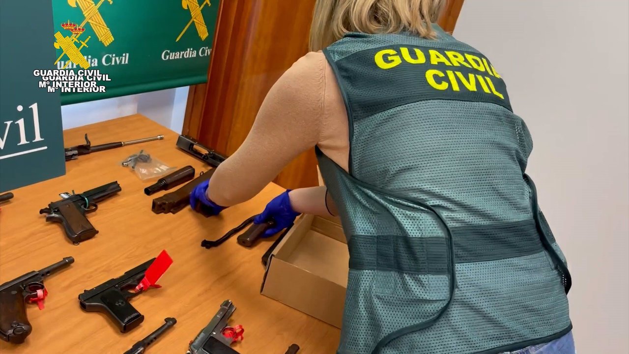 Una agente de la Guardia Civil con algunas de las armas intervenidas en la operación (foto: Guardia Civil)