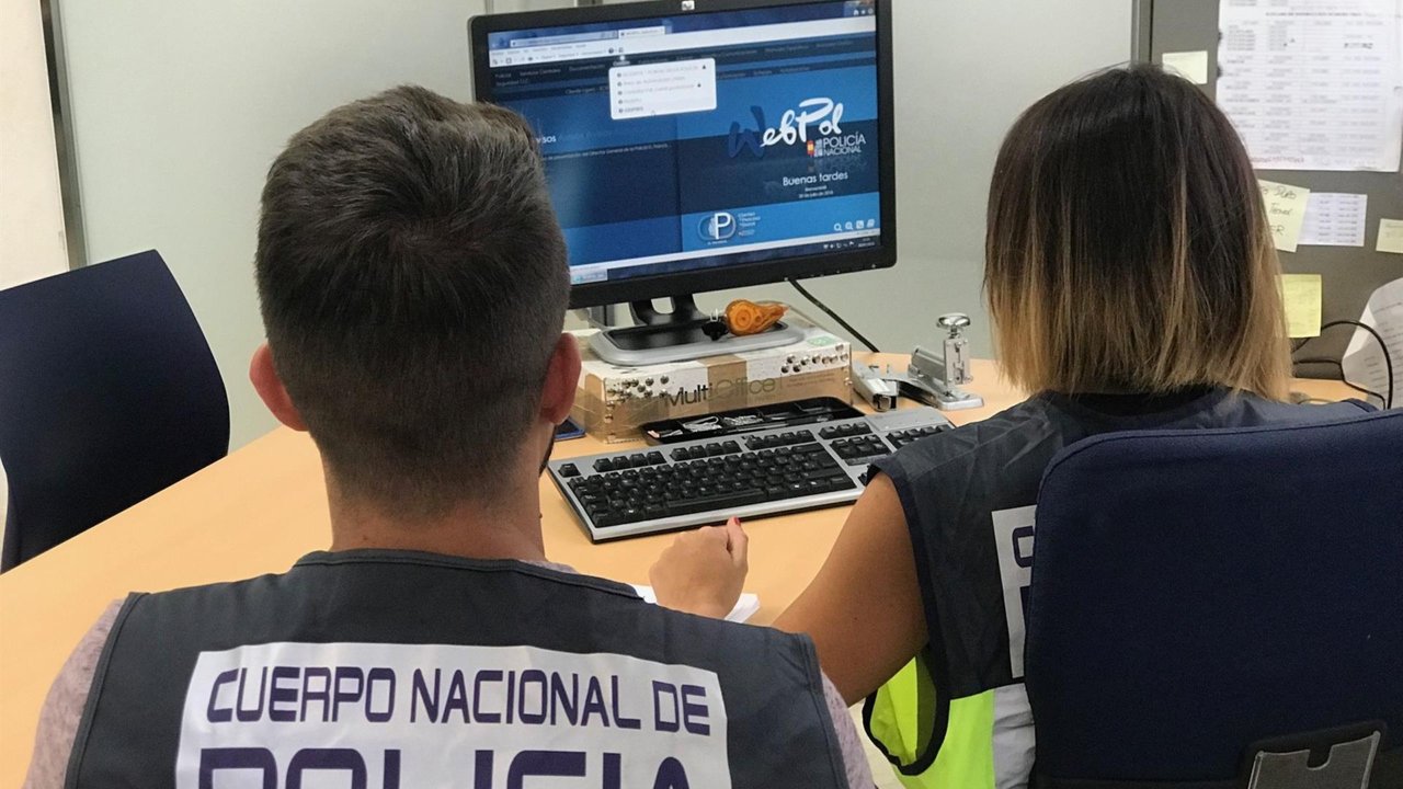 Agentes de la Policía Nacional delante de un ordenador