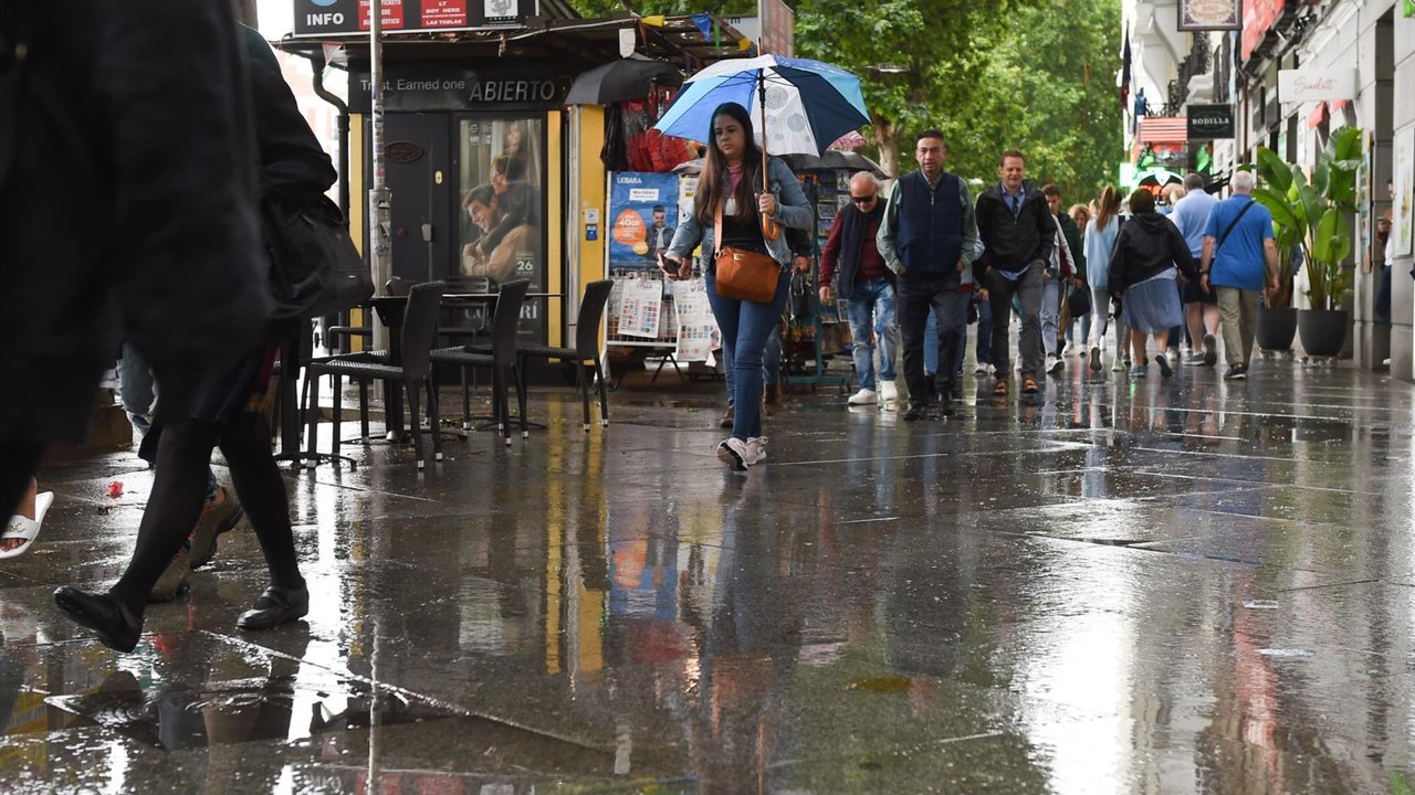 Varias personas pasean bajo la lluvia (Foto: Gustavo Valiente-EP)