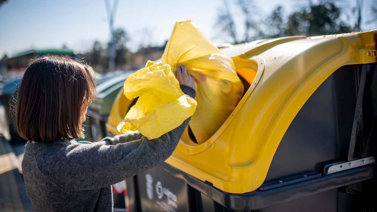 Una ciudadana echa al contenedor algunos residuos reciclables