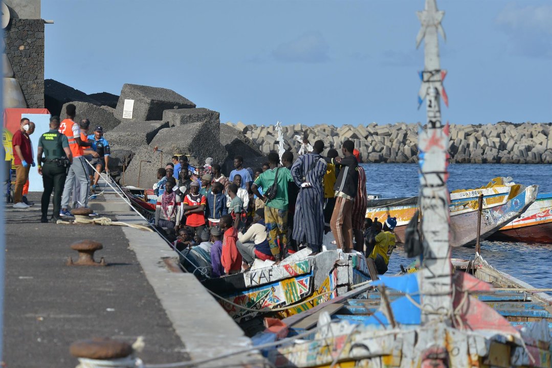 Trabajadores de la Cruz Roja y agentes de la Guardia Civil al lado de uno de los cayucos que ha llegado al puerto de La Restinga (foto: EP)