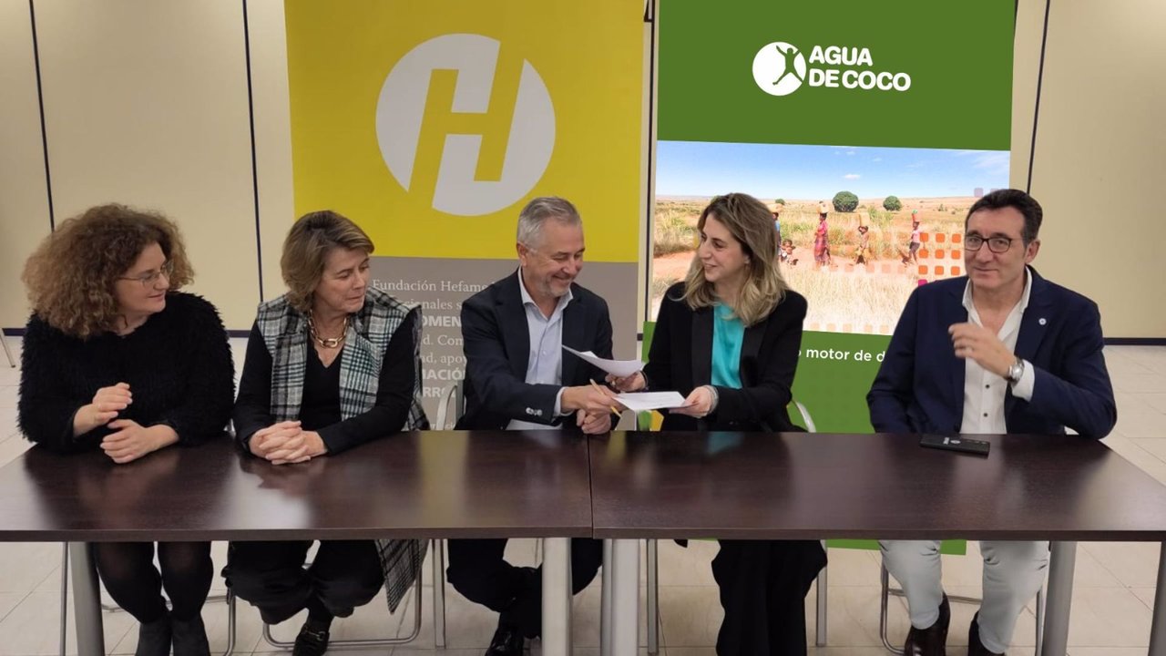 El consejero de Hefame y secretario de su Fundación, Carlos Fernández, y la gerente de la organización Agua de Coco, Sandra Fernández, firman el acuerdo - GRUPO HEFAME