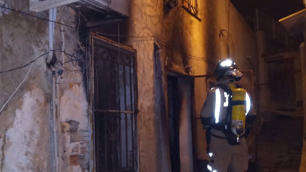 Un bombero inspecciona la casa incendiada en Ricote (Murcia) en la que han fallecido tres personas