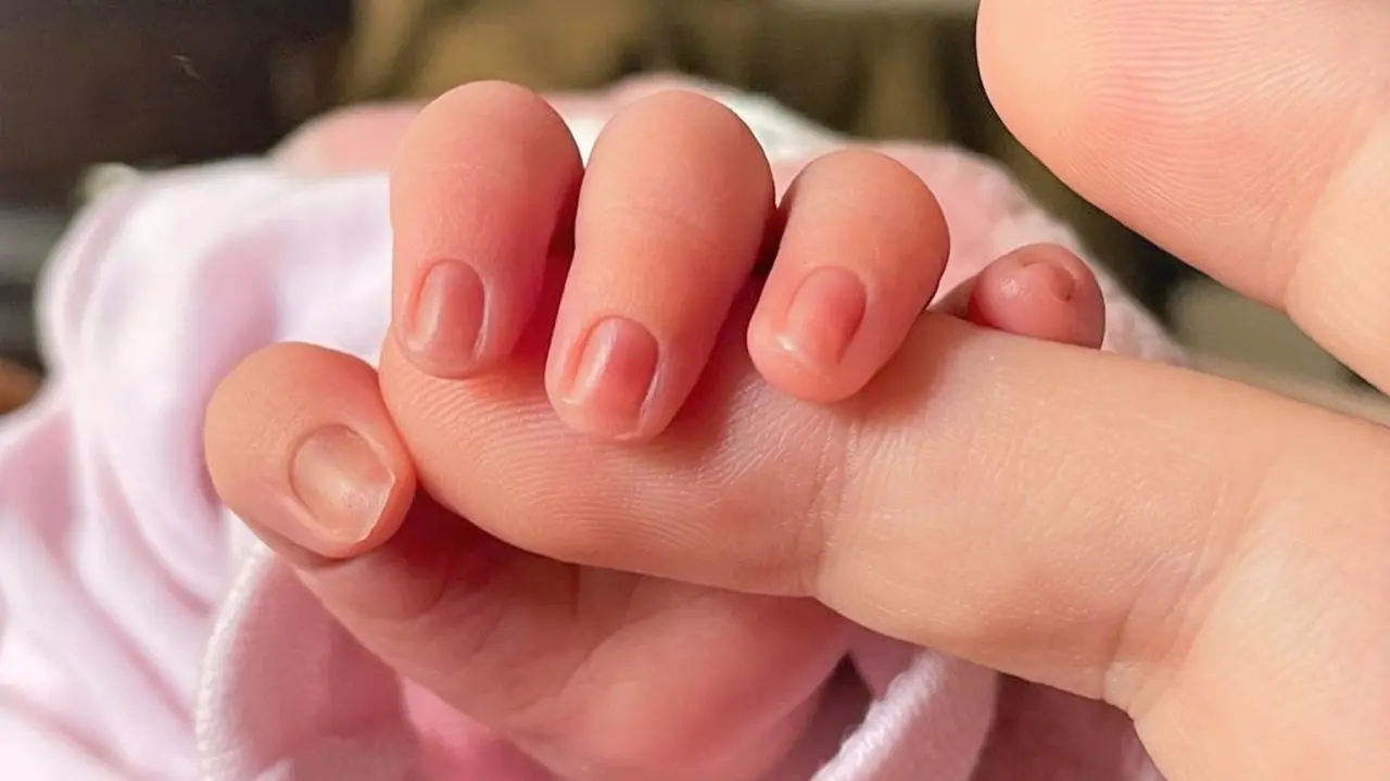 Un beb&eacute; de pocos d&iacute;as de edad coge el dedo de su madre