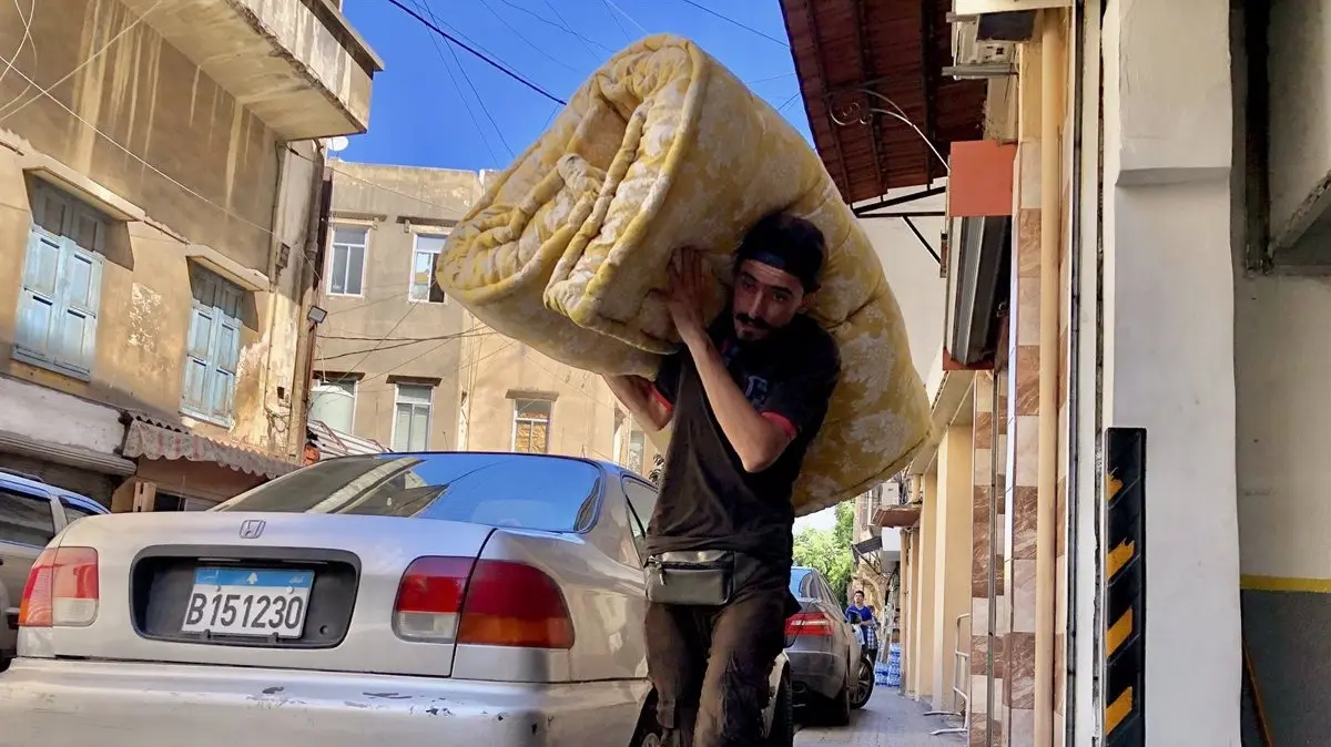 Un hombre traslada una manta para los desplazados en la capital de L&iacute;bano, Beirut, tras la oleada de bombardeos de Israel contra territorio liban&eacute;s  (foto: EP)