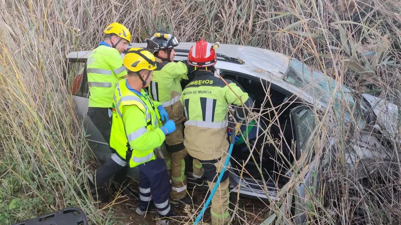 Efectivos sanitarios y del CEIS maniobran para sacar a la mujer del veh&iacute;culo accidentado (foto: CEIS)