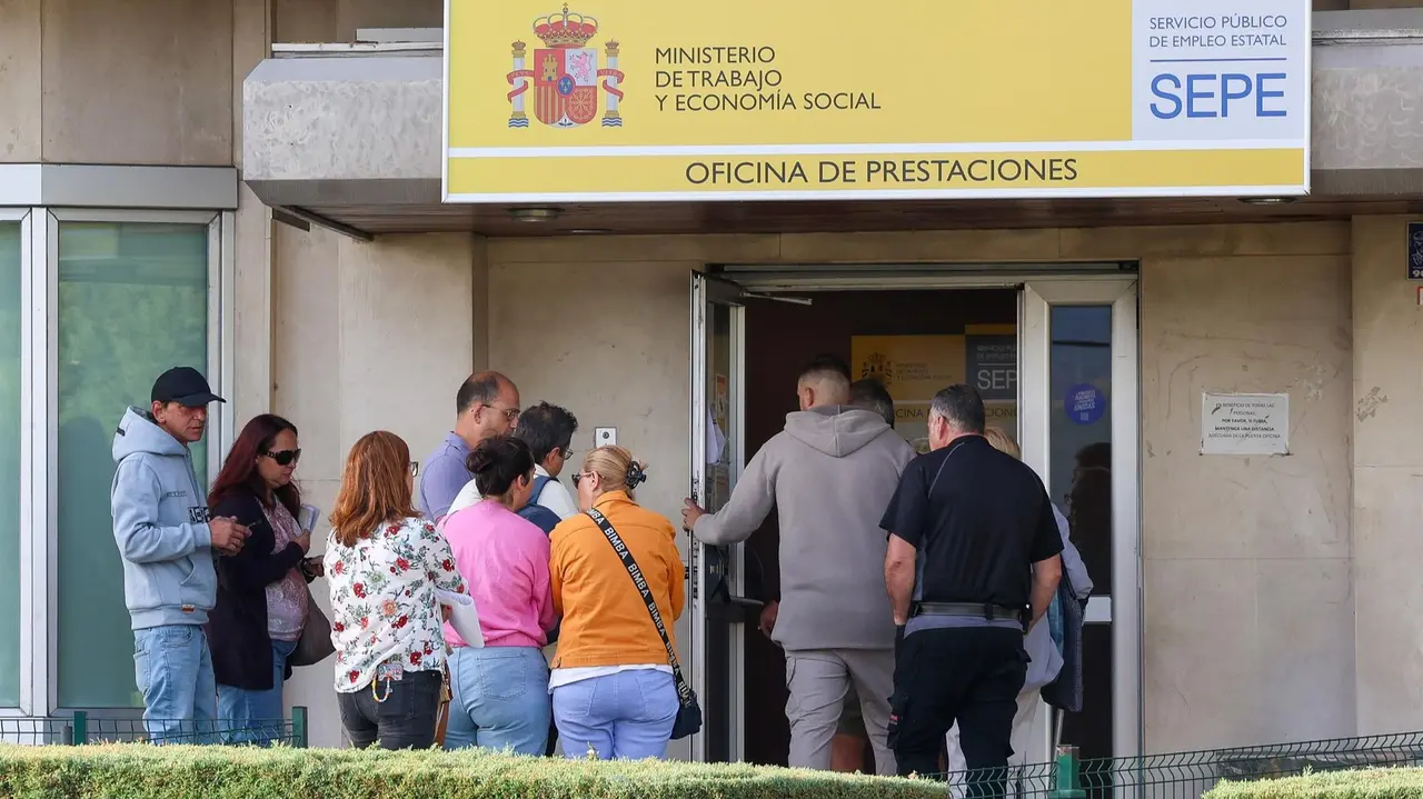 Varias personas en la entrada de una oficina del SEPE