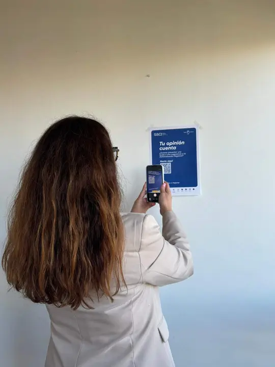 Una ciudadana, haciendo uso de los c&oacute;digos QR instalados para sustituir los buzones f&iacute;sicos