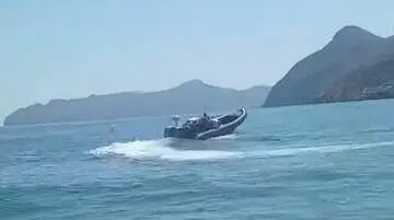 Ba&ntilde;istas graban el traslado de garrafas de combustible a una lancha en la playa de El Port&uacute;s, en Cartagena (foto: La 7)