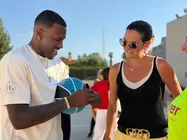 Dylan Ennis firma un bal&oacute;n a la alcaldesa de Archena en su visita a la Escuela Inclusiva (foto: Ayuntamiento de Archena)