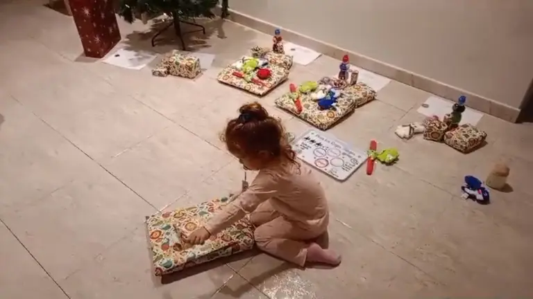 Una ni&ntilde;a abre un regalo el d&iacute;a de Reyes