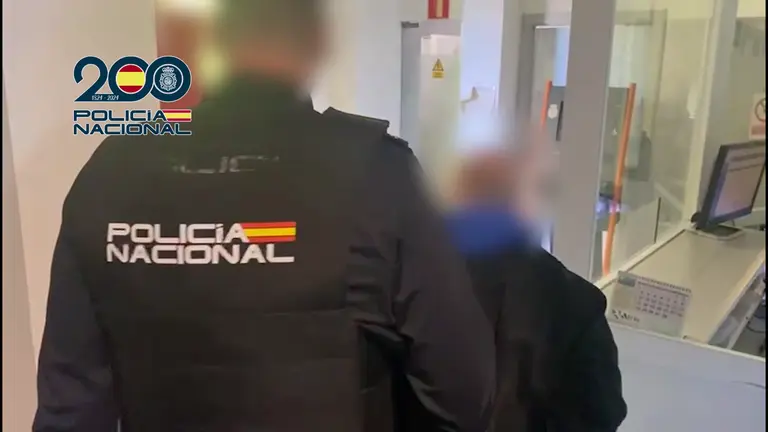 Un agente de la Polic&iacute;a Nacional con uno de los detenidos (foto: PN)