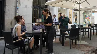 Una camarera atendiendo las mesas de un bar (foto: EP)