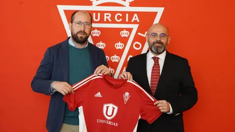 El gerente del Real Murcia, Jos&eacute; Manuel S&aacute;nchez (izq.) junto a Benito Mercader, CEO de Universae, posando con la nueva camiseta de entrenamiento del equipo grana (foto: Real Murcia)