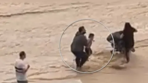 Imagen del momento en el que un hombre rescataba a un beb&eacute; de la riada (foto: La 7)