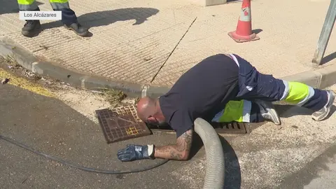 Un operario de limpieza del municipio de Los Alc&aacute;zares realiza trabajos de limpieza de una rejilla situada en el lateral de una carretera (foto: La 7)