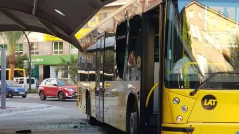 La imagen viral donde se puede observar un autob&uacute;s con los cristales rotos en Avda. D&iacute;az de Revenga (foto: La 7)