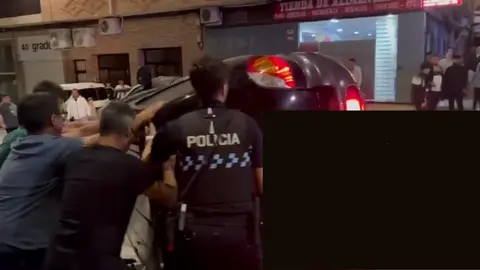 Varios vecinos de Bullas, junto con la Polic&iacute;a Local, intentan darle la vuelta a un coche que hab&iacute;a volcado tras un accidente (foto: La 7)