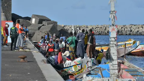 Trabajadores de la Cruz Roja y agentes de la Guardia Civil al lado de uno de los cayucos que ha llegado al puerto de La Restinga (foto: EP)