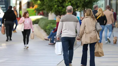 Varias personas caminan con bolsas por un paseo (foto: EP)