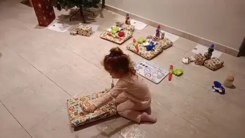 Una ni&ntilde;a abre un regalo el d&iacute;a de Reyes