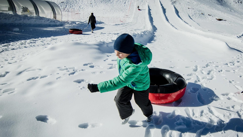 Un ni&ntilde;o se dispone a lanzarse con un flotador en la zona de Borreguiles de la Estaci&oacute;n de Sierra Nevada