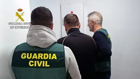 Los agentes custodian a uno de los detenidos (foto: Guardia Civil)
