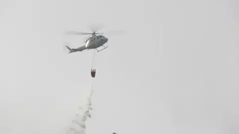 Uno de los helic&oacute;pteros que han acudido al lugar del incendio trata de ayudar en las labores de extinci&oacute;n (foto: La 7)