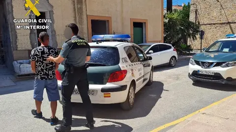 Un agente de la Guardia Civil conduce al detenido al veh&iacute;culo tras la detenci&oacute;n (foto: GC)