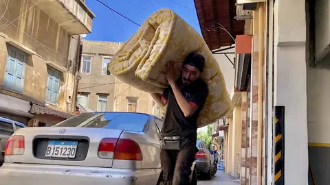 Un hombre traslada una manta para los desplazados en la capital de L&iacute;bano, Beirut, tras la oleada de bombardeos de Israel contra territorio liban&eacute;s  (foto: EP)