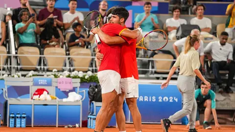 Rafael Nadal y Carlos Alcaraz se abrazan tras una victoria en Paris 2024 (foto: EP)