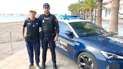 El agente de Polic&iacute;a Nacional posa junto al corredor al que salv&oacute; la vida