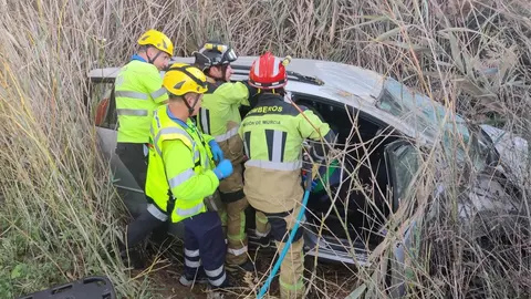 Efectivos sanitarios y del CEIS maniobran para sacar a la mujer del veh&iacute;culo accidentado (foto: CEIS)