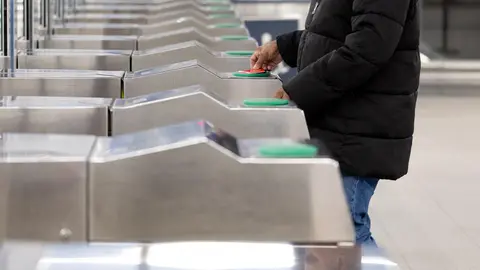 Un usuario del tren pasa su abono transporte