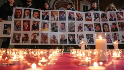 Varias personas sostienen un cartel con im&aacute;genes de algunos fallecidos, durante una conmemoraci&oacute;n por las v&iacute;ctimas de la DANA en Valencia