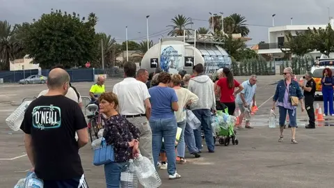 Vecinos llenando garrafas de agua potable