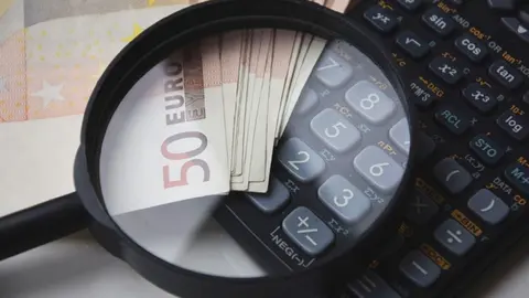 Foto de archivo de una calculadora con dinero
