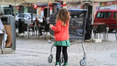 Una ni&ntilde;a camina junto a la terraza de un bar en el centro de Madrid (foto: EP)