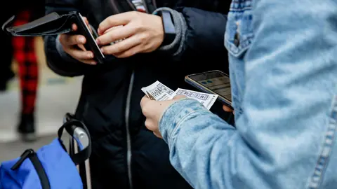 Una persona sostiene dos d&eacute;cimos de el sorteo de El Ni&ntilde;o