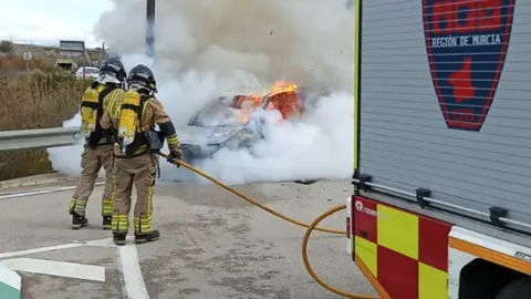 Bomberos sofocando el incendio del veh&iacute;culo en Molina de Segura