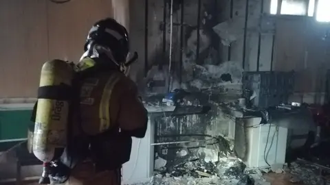 Un bombero trabaja en las labores de extinci&oacute;n de un incendio originado en el s&oacute;tano de una vivienda (foto: 112 de la Regi&oacute;n de Murcia)