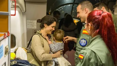 Una mujer y su beb&eacute; a la llegada a Madrid de los pasajeros evacuados desde Om&aacute;n.