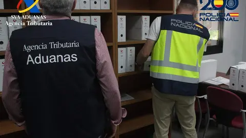 Un agente de la Polic&iacute;a Nacional y un funcionario de Vigilancia Aduanera durante la investigaci&oacute;n