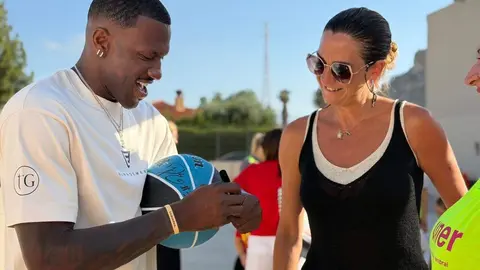 Dylan Ennis firma un bal&oacute;n a la alcaldesa de Archena en su visita a la Escuela Inclusiva (foto: Ayuntamiento de Archena)
